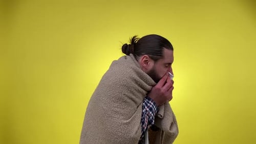 Man with a Cold Shivers Under Blanket