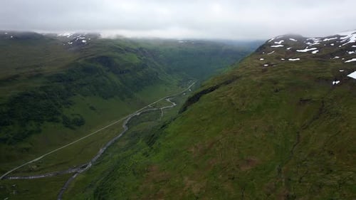 Grünes Gebirgstal mit Fluss und niedrigen Wolken — Norwegen, Luftaufnahme