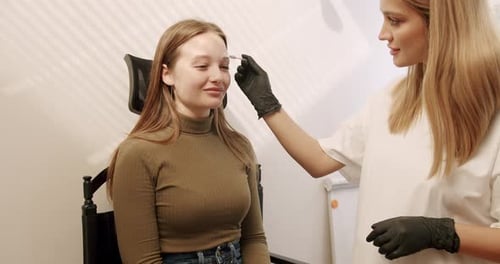 Beautician Applying Makeup to Woman's Eyebrows
