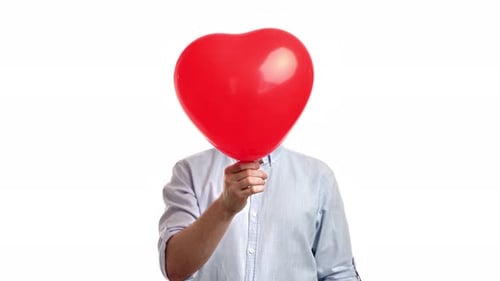 Person Holding Heart Balloon in Front of Face