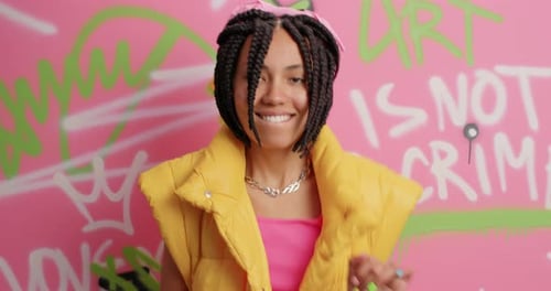 Happy Woman Dancing and Smiling near Graffiti Wall