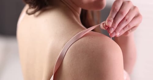 Femme ajustant la sangle d'un beau soutien-gorge à l'intérieur, gros plan