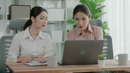 Two Young Enthusiastic Businesswoman Working Together in the Office Workspace