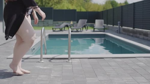 Slow motion footage feet by the pool of woman and man enjoying leisure time