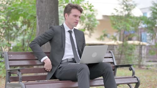 Businessman Working on Laptop Gets Back Pain