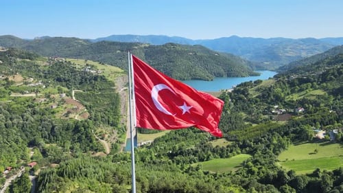 Turkish Flag Waving Over Scenic Green Landscape