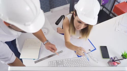 Architects Reviewing Plans Together at Desk