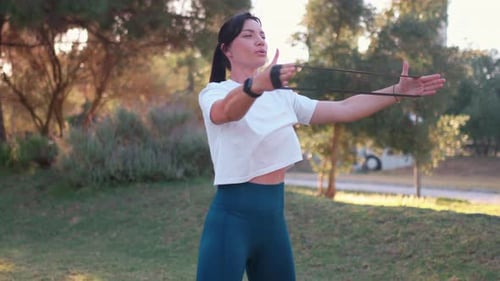 Woman Exercising with Resistance Band in Park