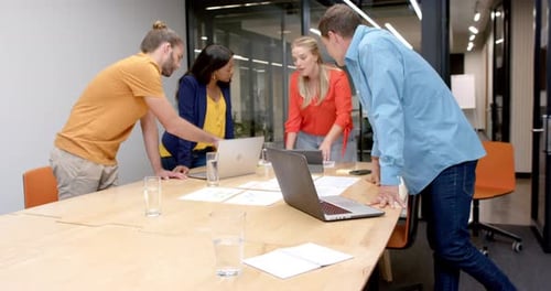 A diverse team collaborates in a casual business, modern office setting, with copy space