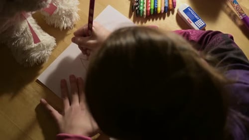 nettes kleines Mädchen, das beim Zeichnen auf Papier mit Bleistiften neue Kunstfertigkeiten lernt