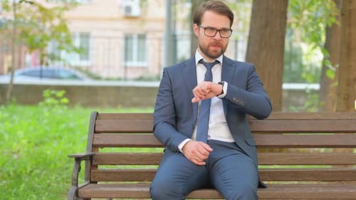 Man in Suit Waiting on Park Bench Checking Watch