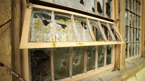 Dilapidated Building with Broken Window and Decaying Paint