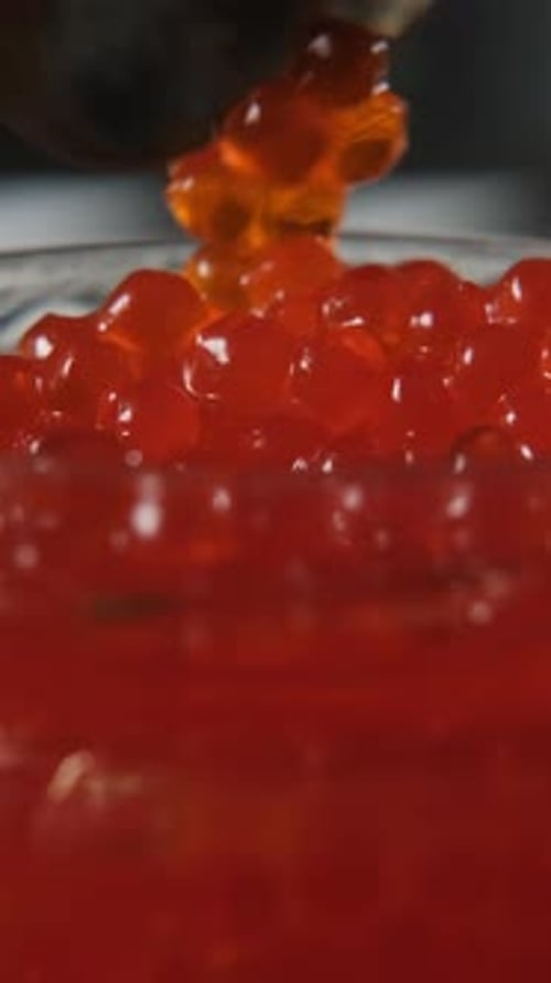 Spoon Lifting Red Caviar From Glass Jar