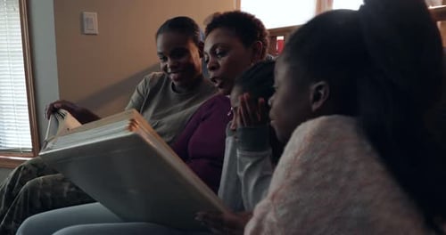 Family Looking at Photo Album Together at Home