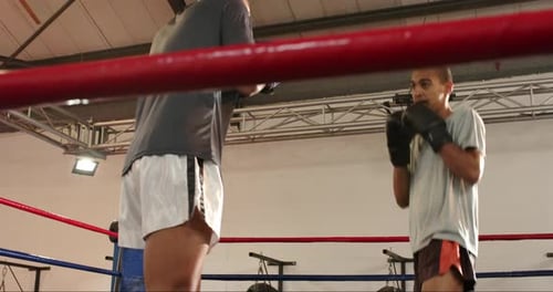 Betreten den Boxring, zwei männliche Sparringspartner tauschen während des Trainings Stöße und Kreuze aus