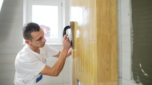 Man Grouting Wood Look Tile on Wall