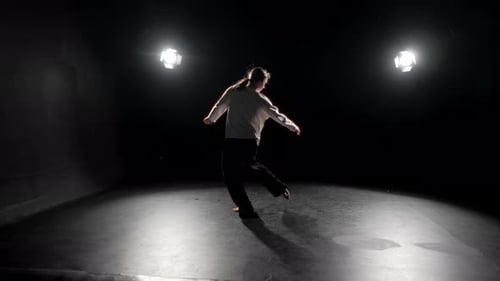 Young Blonde Woman Dancing in Dark Room