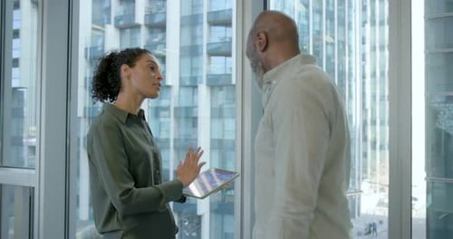 Two Business People Discussing Presentation on Digital tablet, Working and Meeting in Office