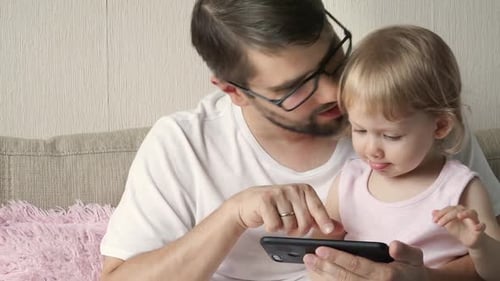 Close Up Portrait of Father with Little Daughter Use Mobile Phone