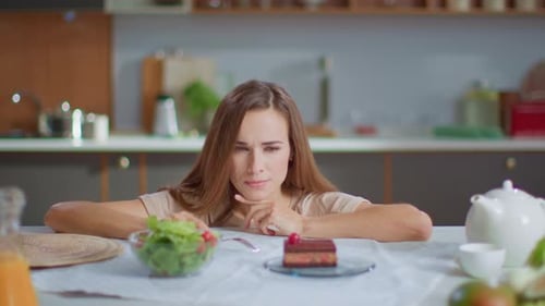 Woman Faces Salad and Cake with Contradictory Emotions