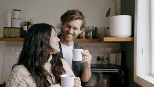 Happy Couple Drinking Coffee in a Sunny Kitchen