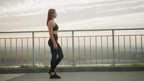 Pretty Woman Walking Majestically Beside Iron Fence Looking Ahead