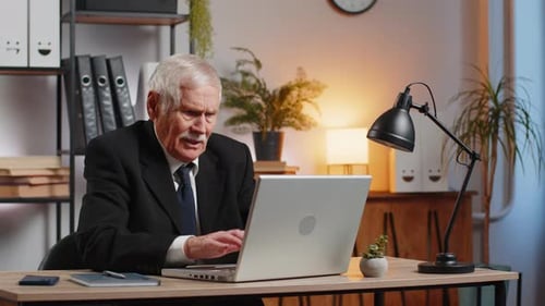 Frustrated Senior Businessman Grandpa in Suit Having Software Problems with Laptop at Home Office