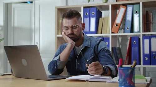 Un employé de bureau Bored Hipster Guy souffre d'un manque de motivation et d'intérêt pour la profession assise