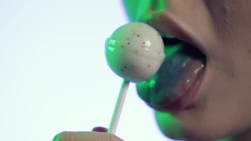 woman licking popsicle, licking lipstick lips, mouth close-up shot on yellow background
