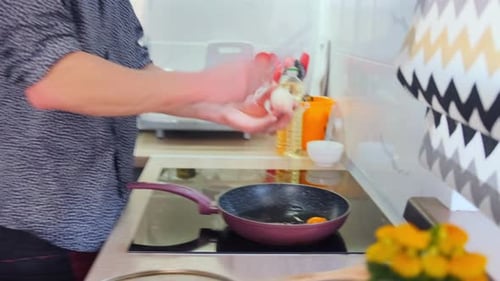 Scène de cuisson des œufs individuels faisant frire des œufs dans une cuisine ensoleillée Une personne cassant des œufs dans une poêle chaude pour