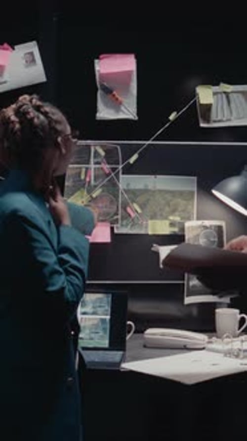 Detectives Examining Crime Investigation Board at Night