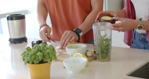 Left is placing and chopping garlic on board, right is pouring powder into blender making dressing