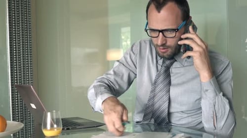 Businessman working at home using phone and laptop