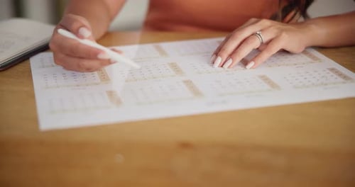 Woman Planning Schedule with Pen on Calendar