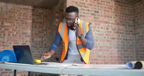 Architect, phone call and laptop with black man in building for structure engineer
