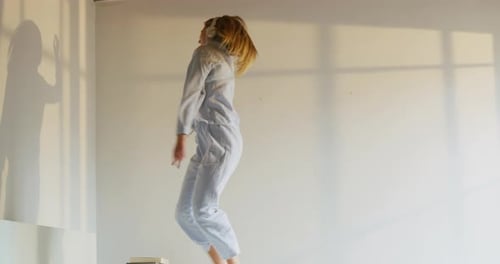 Joyful Young Woman Dancing in Bedroom