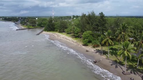 Vista aérea das ondas do mar rolando em uma bela praia com areia rosa ao nascer do sol