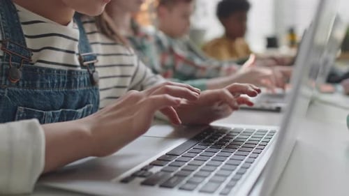 Kleines Mädchen benutzt Laptop während des Computerunterrichts in der Grundschule