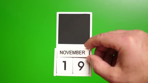 Hand Changes November Calendar Date on Green Screen