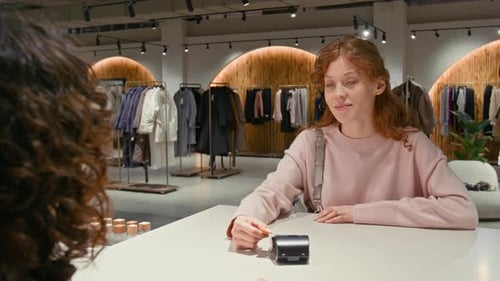 Woman Purchases Clothes at a Modern Boutique