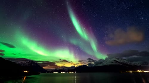 Dreamlike time-lapse over Lyngen fjord with green aurora borealis, Skibotn