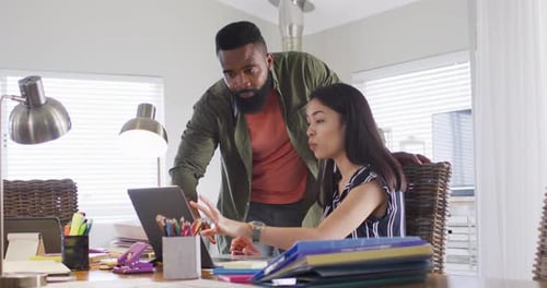 Divers amis masculins et féminins utilisant un ordinateur portable et parlant, travaillant à la maison, Ralenti