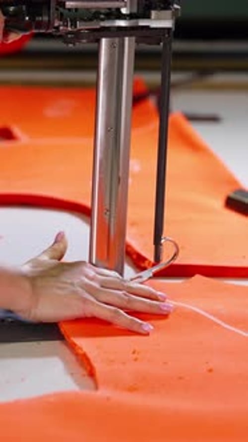 Seamstress works on sewing machine. Female worker hand in textile garment manufacturers.