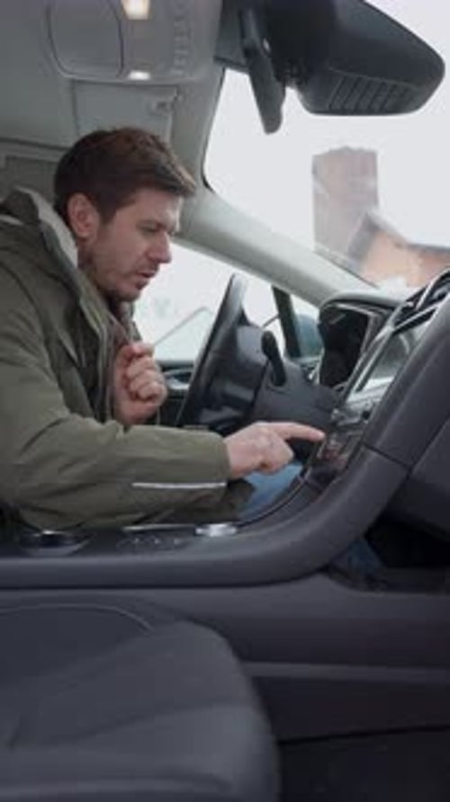 Man warming hands in car on a cold day