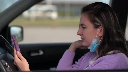 Woman Using Mobile Phone in Car