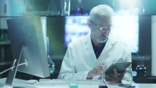 Scientist Works on Computer and Tablet in Lab