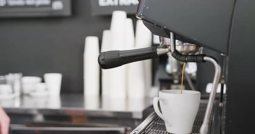 Caucasian male barista preparing coffee with coffee machine in cafe