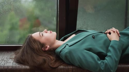 Woman Lying by Rainy Window