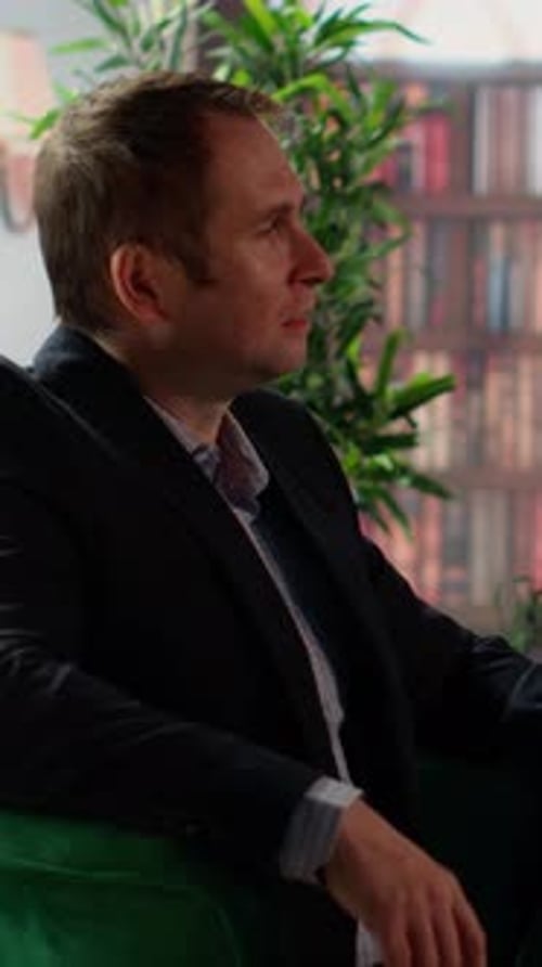 Vertical Video Two Multiethnic Businessmen Sharing a Whiskey Glass in an Elegant Library
