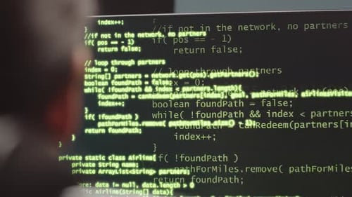Programmer Looking at Sophisticated Code on Desktop Computer